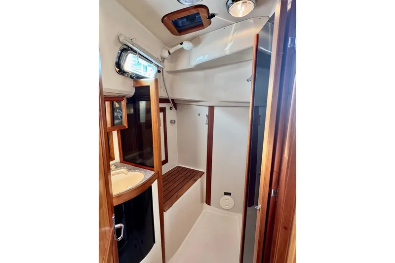 Slide: The Image of Interior of 2000 Sabre 402 sailboat, featuring a compact bathroom with wooden accents. - 33