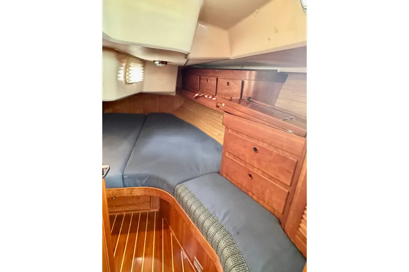 Slide: The Image of Cozy cabin interior of 2000 Sabre 402 sailboat with wooden cabinetry and cushioned seating. - 35
