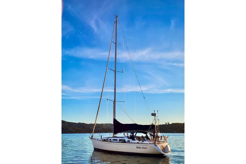 Slide: The Image of Sailboat Sabre 402, 2000 model, on calm water under a clear blue sky. - 4