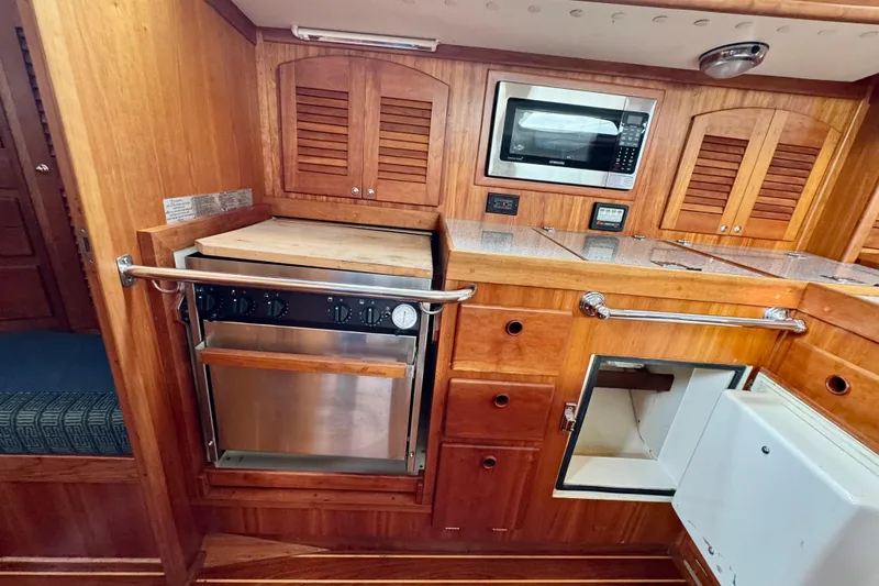 Slide: The Image of Wooden yacht kitchen with stove, microwave, and storage cabinets, Sabre 402, year 2000. - 46