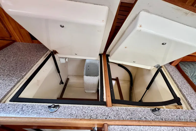 Slide: The Image of Open storage compartments on a 2000 Sabre 402 yacht with granite-like countertops. - 47