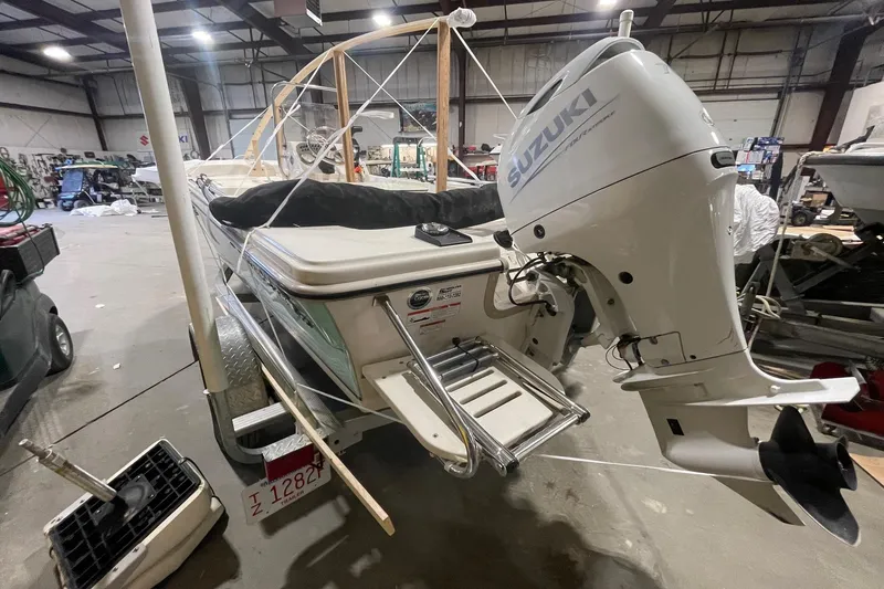 Slide: The Image of 2021 Carolina Skiff 162 JLS with Suzuki outboard motor in a warehouse setting. - 4