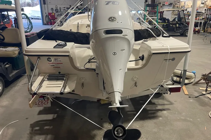 Slide: The Image of 2021 Carolina Skiff 162 JLS boat in a garage, rear view with motor and ladder. - 5