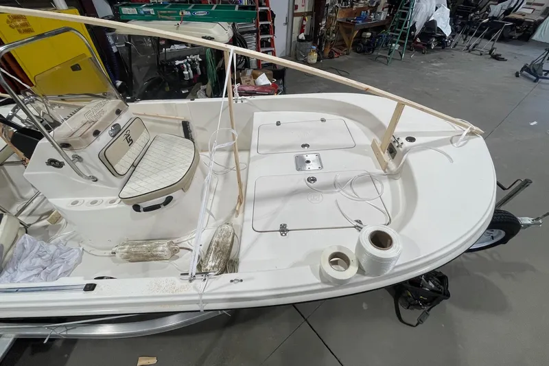 Slide: The Image of 2021 Carolina Skiff 162 JLS boat interior with seating and equipment in a workshop. - 8
