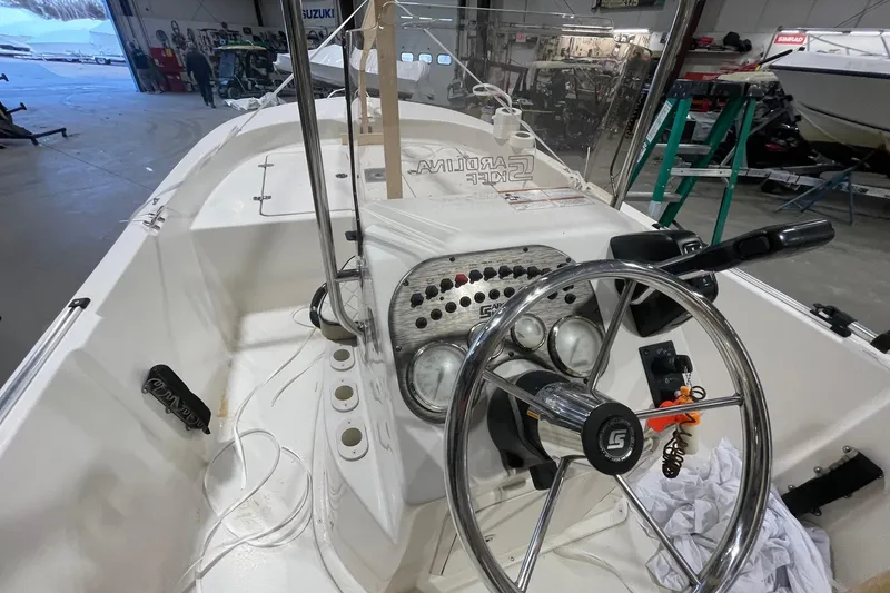 Slide: The Image of 2021 Carolina Skiff 162 JLS boat interior with steering wheel and control panel. - 9