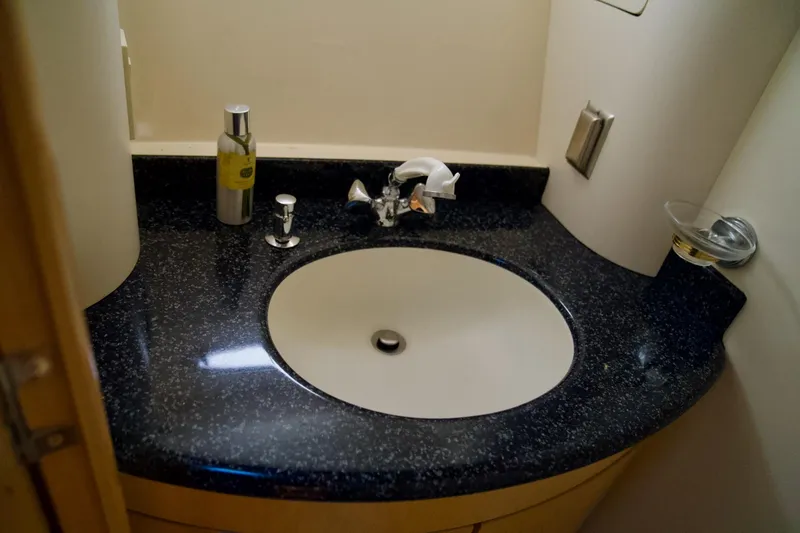 Slide: The Image of Bathroom sink in 2000 Carver 506 Motor Yacht with black countertop and chrome fixtures. - 49