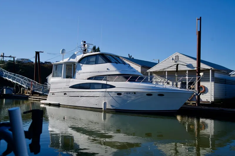 The Image of Carver 506 Motor Yacht 2000 docked beside a marina under clear blue sky. - 0