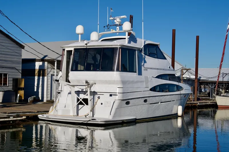 Slide: The Image of 2000 Carver 506 Motor Yacht docked at a marina under clear blue skies. - 2
