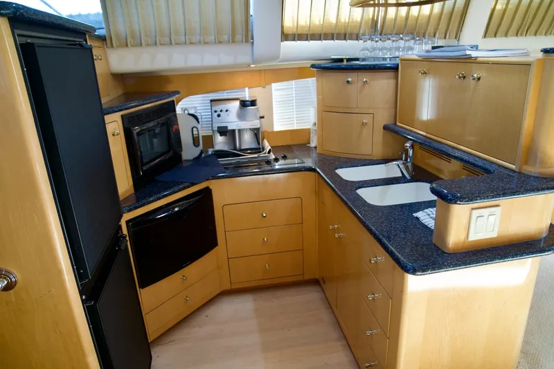 Slide: The Image of Luxurious kitchen in a 2000 Carver 506 Motor Yacht with modern appliances and wood cabinetry. - 32