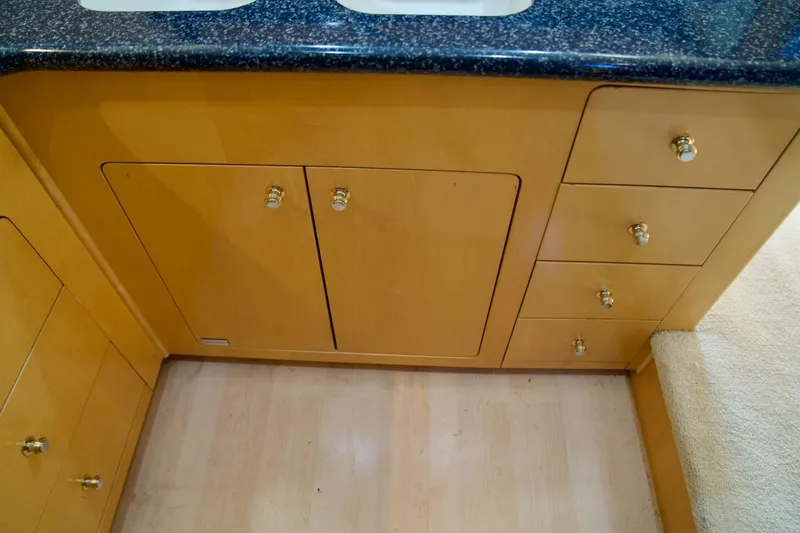 Slide: The Image of Wooden cabinetry with gold knobs in a 2000 Carver 506 Motor Yacht kitchen. - 33