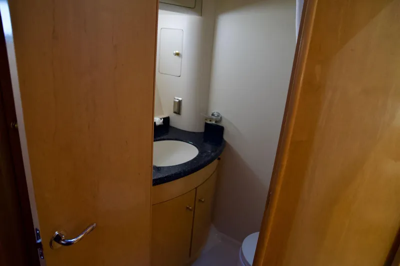 Slide: The Image of Bathroom interior of 2000 Carver 506 Motor Yacht with wooden cabinetry and black countertop. - 53