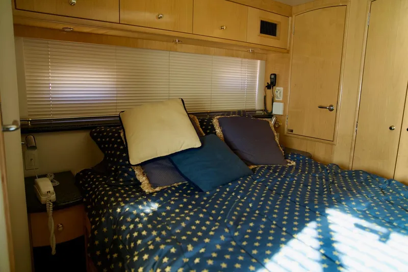 Slide: The Image of Cozy bedroom in 2000 Carver 506 Motor Yacht with star-patterned bedding and wooden cabinetry. - 62
