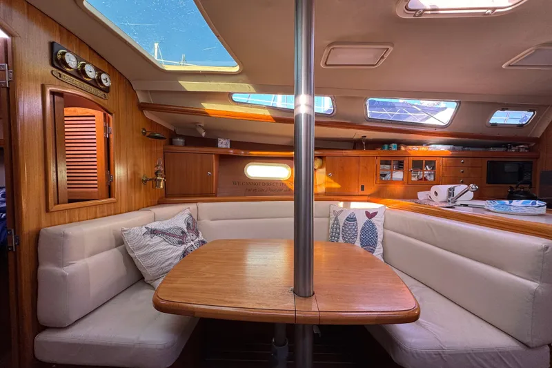Slide: The Image of Cozy interior of a 2005 Hunter 36 sailboat with wooden finishes and seating area. - 11