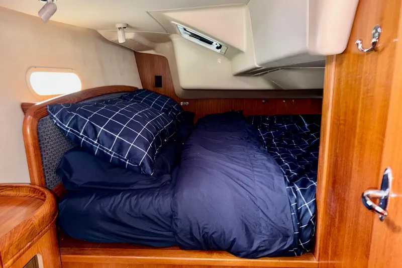Slide: The Image of Cozy cabin interior of 2005 Hunter 36 sailboat with navy bedding and wooden accents. - 14