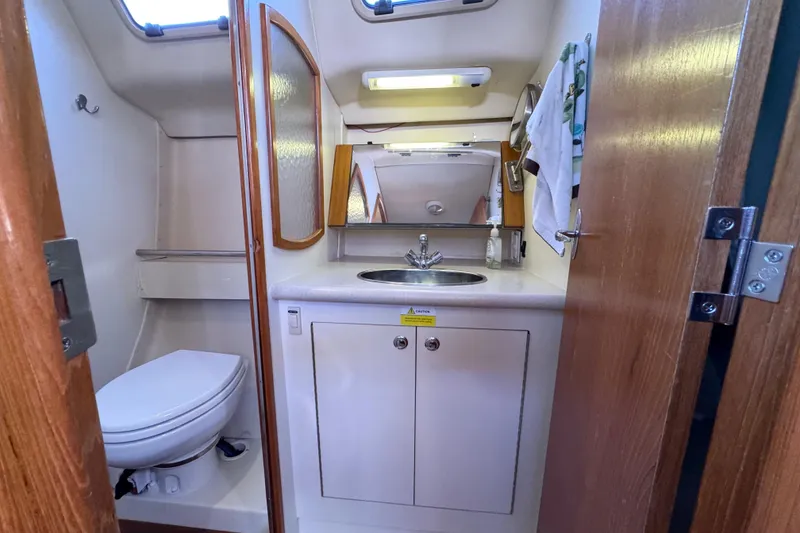 Slide: The Image of Compact bathroom in a 2005 Hunter 36 sailboat with sink, toilet, and mirror. - 15