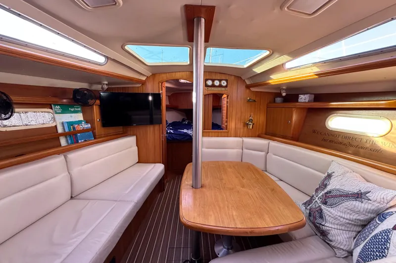 Slide: The Image of Interior of 2005 Hunter 36 sailboat with cozy seating and wooden table. - 2