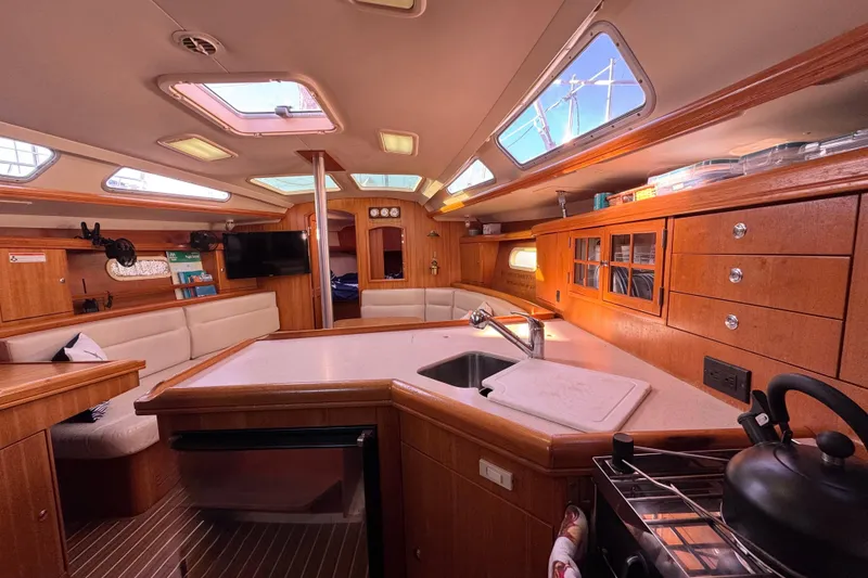 Slide: The Image of Interior of a 2005 Hunter 36 sailboat with modern kitchen and seating area. - 4