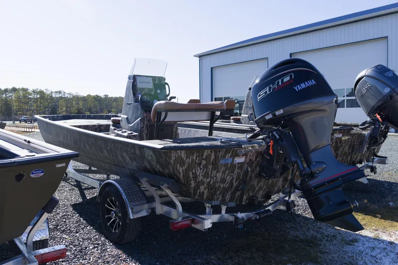 Slide: The Image of 2026 Avid 20 Rogue CC boat with Yamaha outboard motor, parked outdoors. - 2