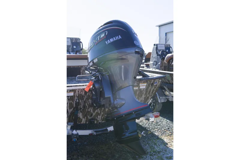 Slide: The Image of Outboard motor on Avid 20 Rogue CC boat, 2026 model, in a yard setting. - 5