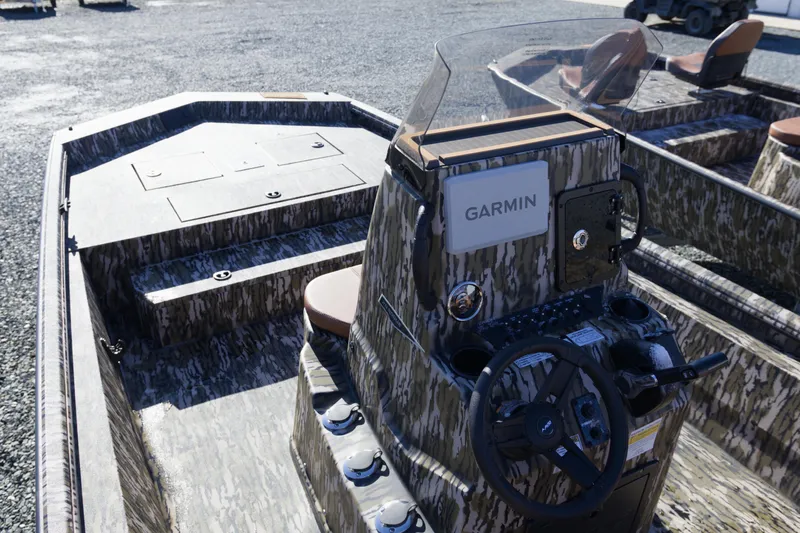 Slide: The Image of 2026 Avid 20 Rogue CC boat with Garmin navigation, camo design, and steering console. - 8