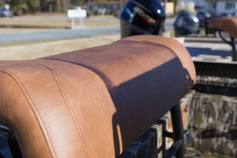 Slide: The Image of Brown leather seat on 2026 Avid 20 Rogue CC boat, with outboard motors in background. - 9