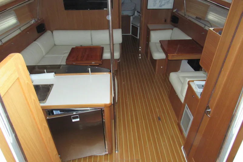 Slide: The Image of 2019 Catalina 425 yacht interior with wood flooring and cozy seating area. - 20