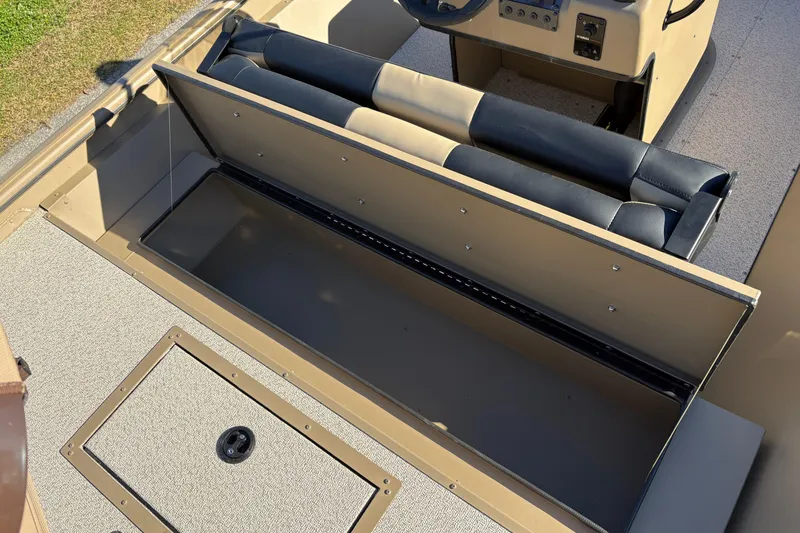 Slide: The Image of 2026 SeaArk Shadow 18 boat interior with open storage compartment and cushioned seating. - 11
