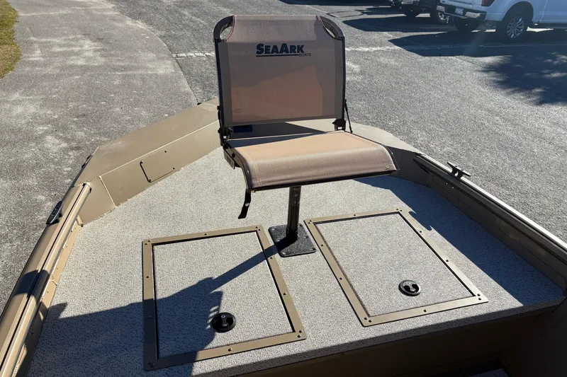 Slide: The Image of 2026 SeaArk Shadow 18 boat with a single seat on deck, parked outdoors. - 16