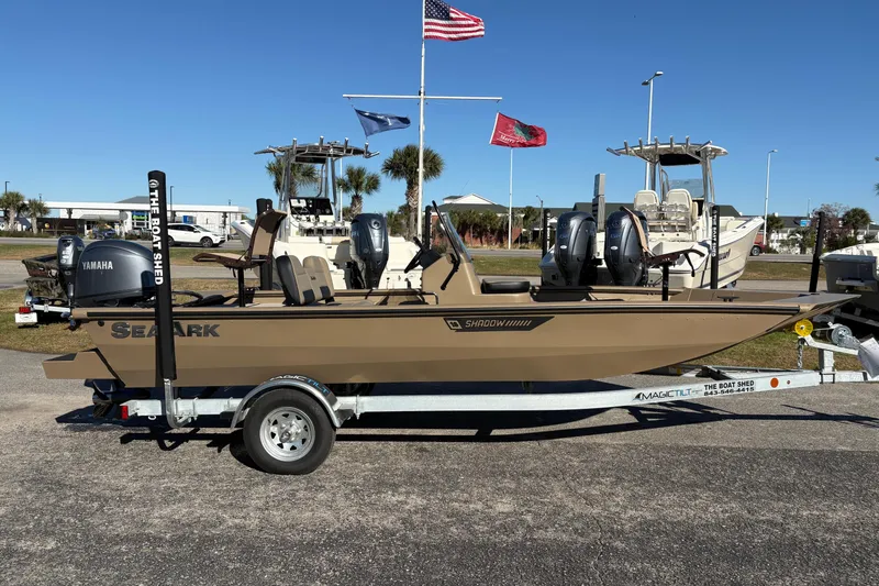 Slide: The Image of 2026 SeaArk Shadow 18 boat on trailer with Yamaha outboard motor, parked outdoors. - 5