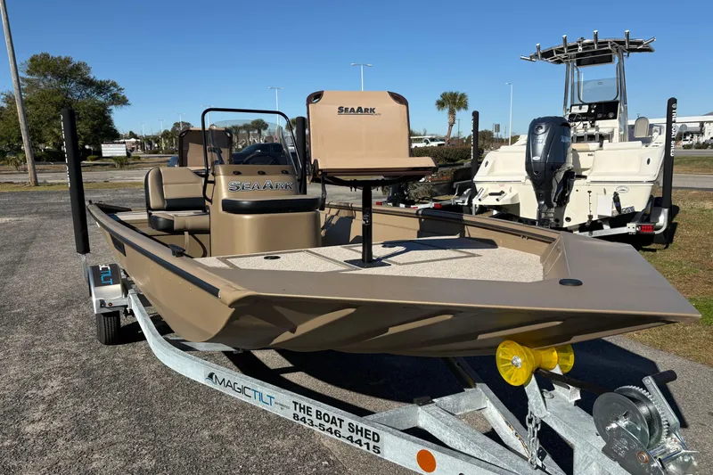 Slide: The Image of 2026 SeaArk Shadow 18 boat on trailer, displayed outdoors under clear blue sky. - 6