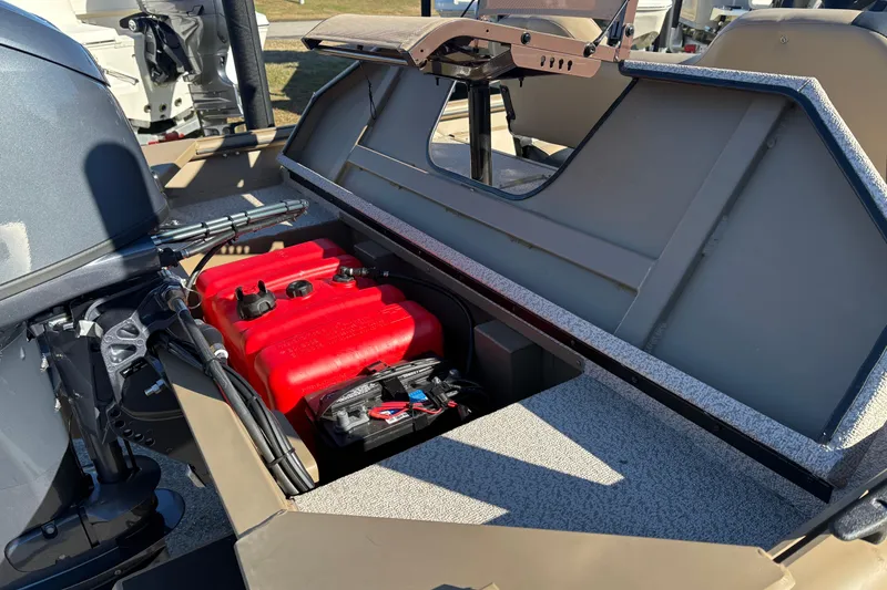 Slide: The Image of 2026 SeaArk Shadow 18 boat with open storage compartment, revealing red fuel tank and battery. - 9