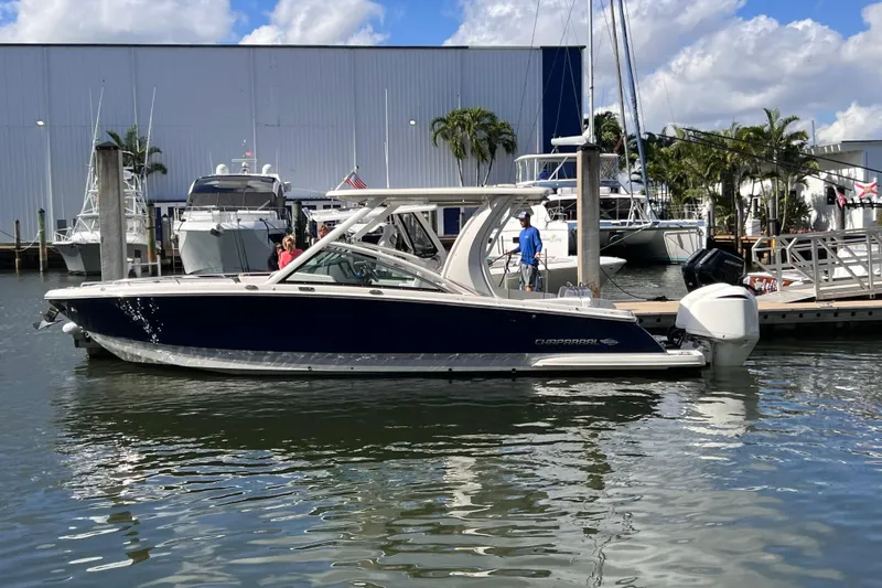 The Image of 2020 Chaparral 300 OSX boat docked at marina under blue sky. - 1
