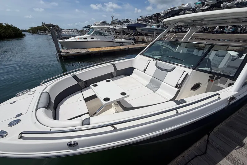 Slide: The Image of 2020 Chaparral 300 OSX boat docked, featuring spacious seating and sleek design. - 11