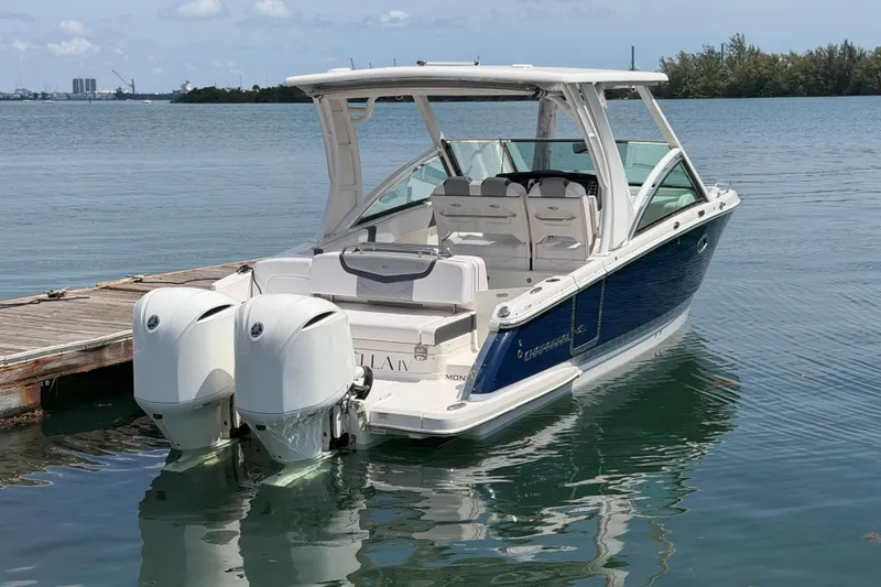 Slide: The Image of 2020 Chaparral 300 OSX boat docked, featuring dual outboard engines and sleek design. - 13