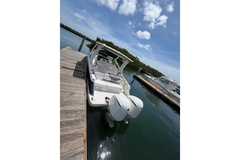 Slide: The Image of Chaparral 300 OSX 2020 boat docked on a sunny day, featuring dual outboard engines. - 14