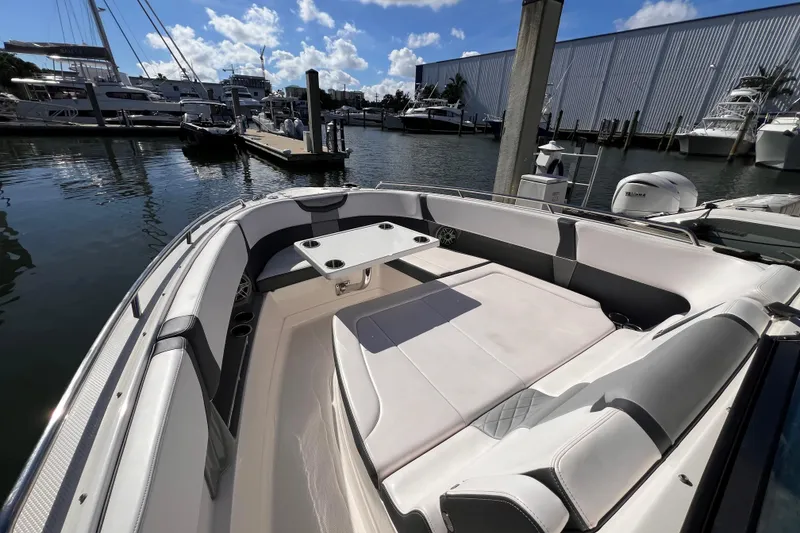 Slide: The Image of 2020 Chaparral 300 OSX boat interior with seating and table at marina. - 3
