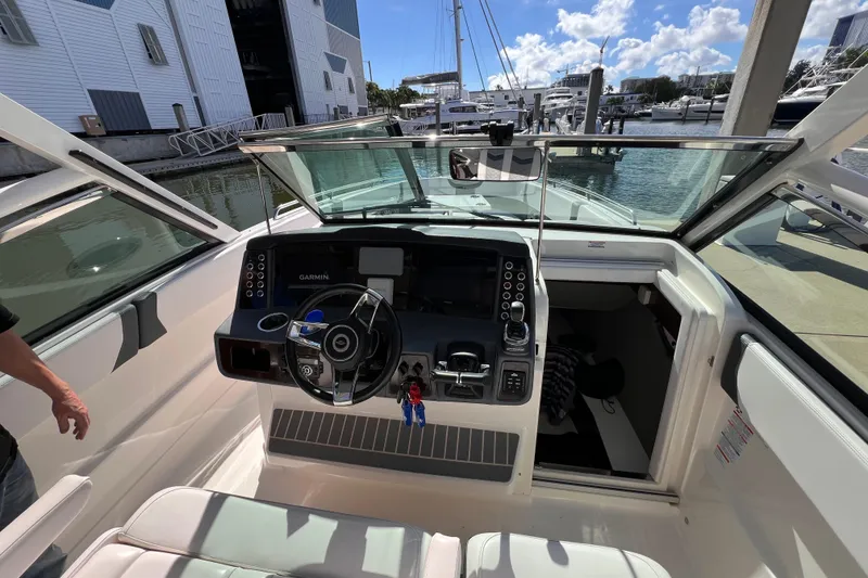 Slide: The Image of 2020 Chaparral 300 OSX boat cockpit with modern controls and marina view. - 6