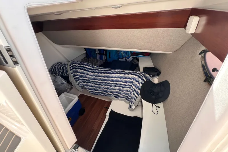 Slide: The Image of 2020 Chaparral 300 OSX cabin interior with striped blanket and accessories. - 7