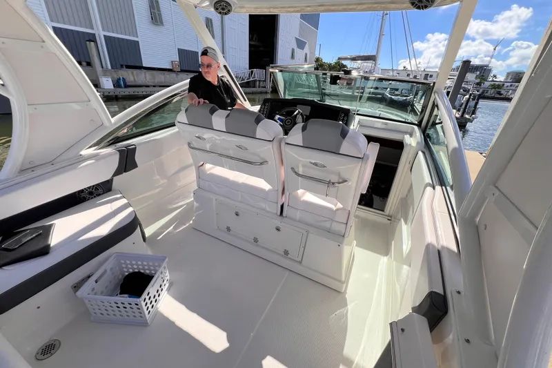 Slide: The Image of 2020 Chaparral 300 OSX boat interior with seating and helm, docked at marina. - 8