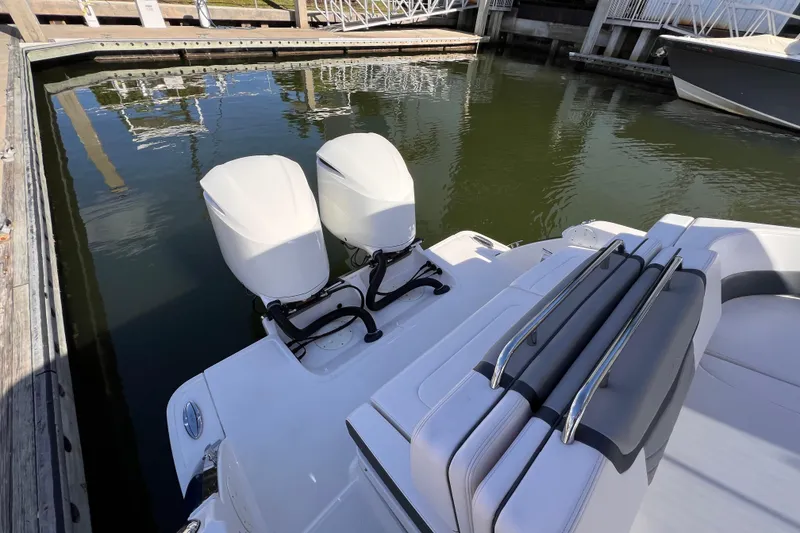 Slide: The Image of 2020 Chaparral 300 OSX boat with dual outboard engines docked in marina. - 9