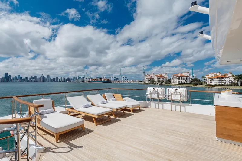 Slide: The Image of Luxurious 2018 Benetti Fast 125 yacht deck with sun loungers, overlooking coastal skyline. - 39