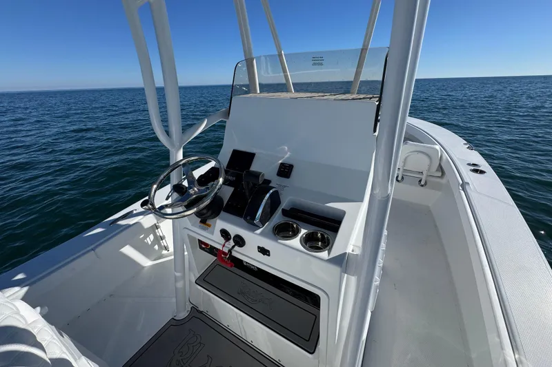 Slide: The Image of 2026 BlackJack 256 Coastal boat dashboard on open sea, featuring steering wheel and controls. - 27