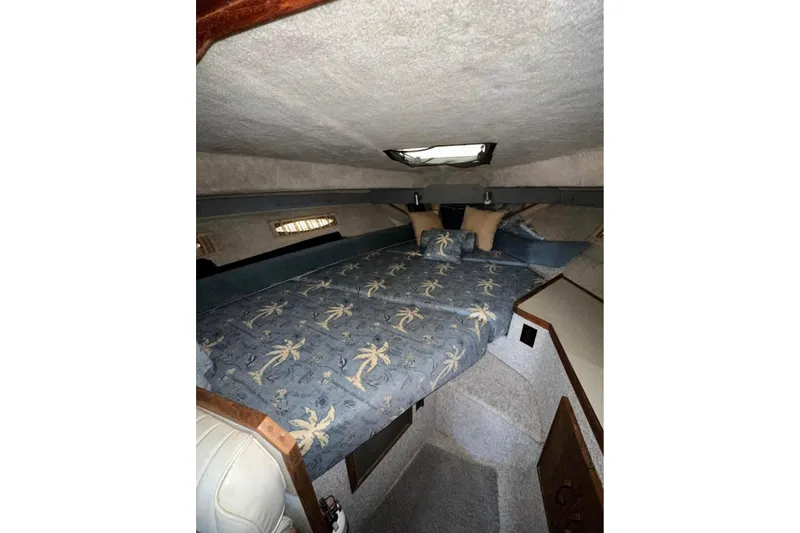 Slide: The Image of 1986 Sea-Ray 340 Express cabin interior with palm tree bedding and cozy sleeping area. - 22