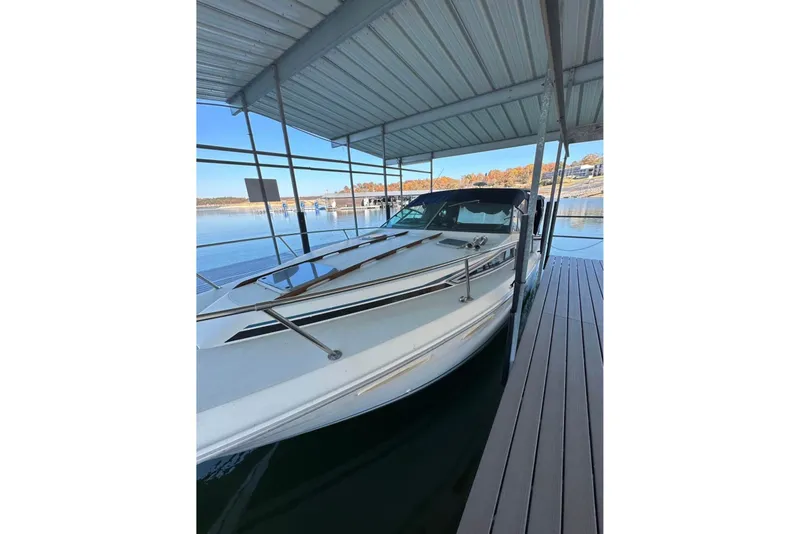 Slide: The Image of 1986 Sea-Ray 340 Express docked under a covered marina. - 5