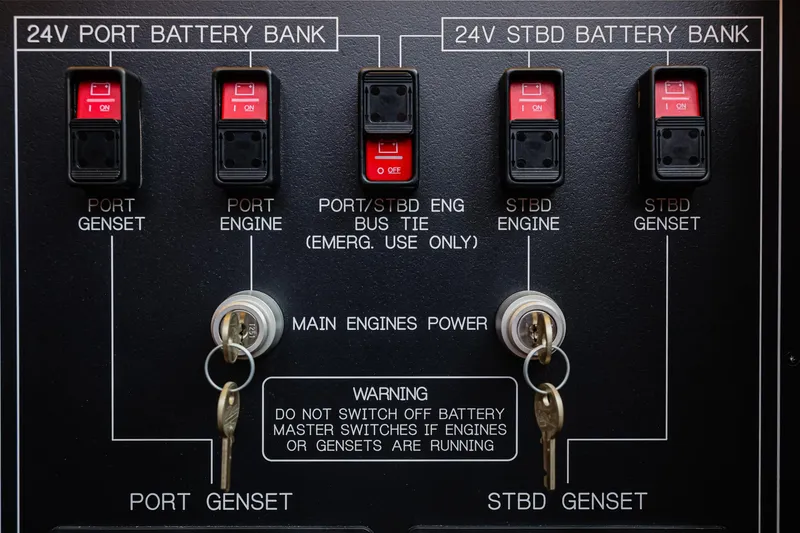Slide: The Image of Control panel of 2027 Fleming 85 Pilothouse with battery switches and warning labels. - 100