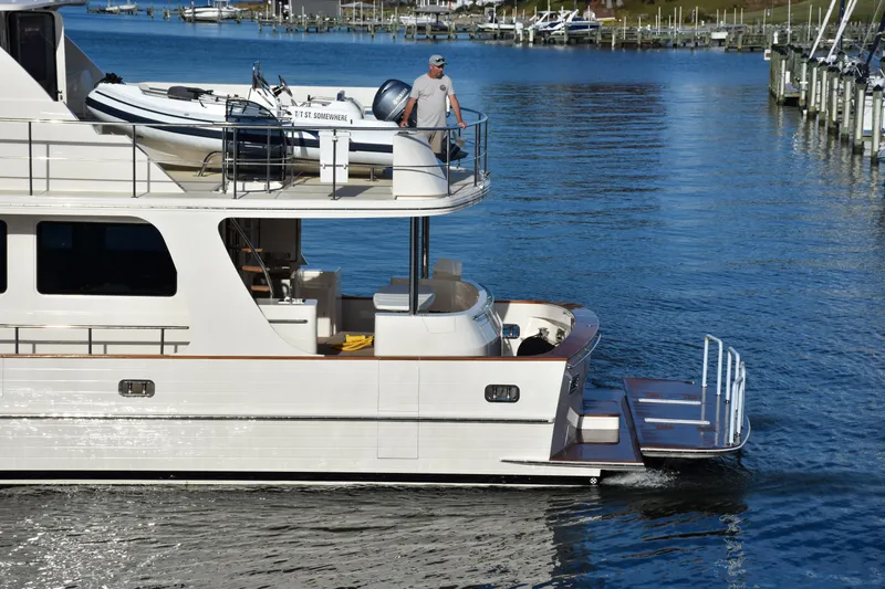 Slide: The Image of Luxury 2027 Fleming 85 Pilothouse yacht cruising in a serene marina setting. - 106