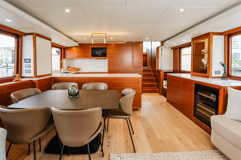 Slide: The Image of Luxurious interior of 2027 Fleming 85 Pilothouse yacht with modern dining and kitchen area. - 14