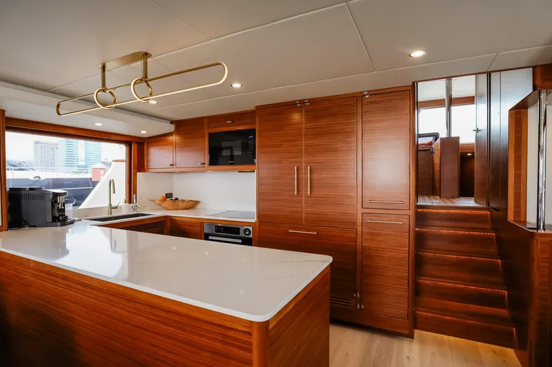 Slide: The Image of Luxurious kitchen interior of 2027 Fleming 85 Pilothouse yacht with modern wood cabinetry. - 15