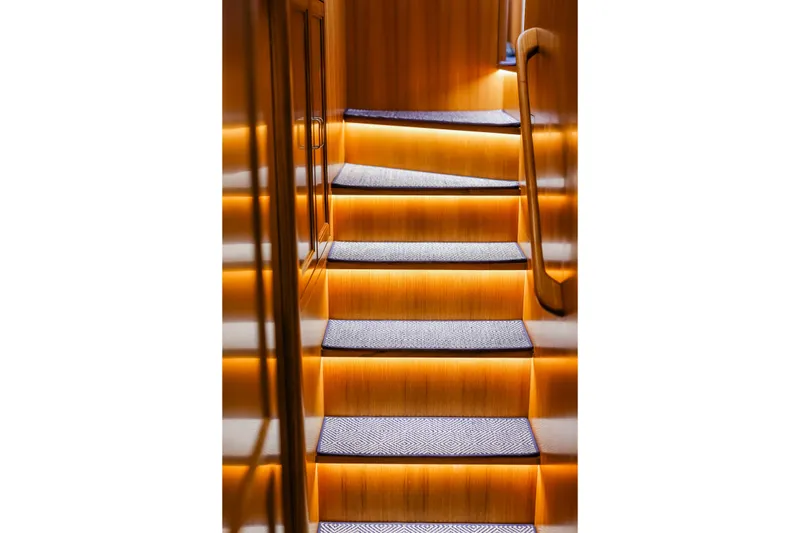 Slide: The Image of Illuminated wooden staircase inside 2027 Fleming 85 Pilothouse yacht. - 39