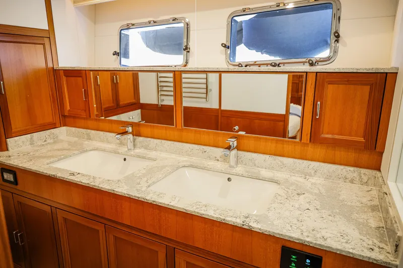 Slide: The Image of Luxurious bathroom in 2027 Fleming 85 Pilothouse yacht with dual sinks and wooden cabinetry. - 43